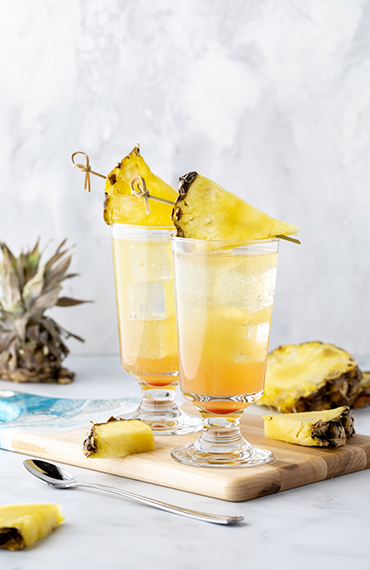 Décorez votre cocktail au rhum et au Champagne avec simplicité : un morceau d’ananas ou un zeste de citron